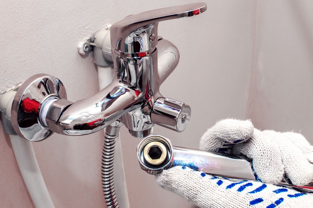 Chrome Faucet Being Repaired With Gloved Hands, a Close-up in a Bathroom Setting — Full On Plumbing & Gas in Parap, NT