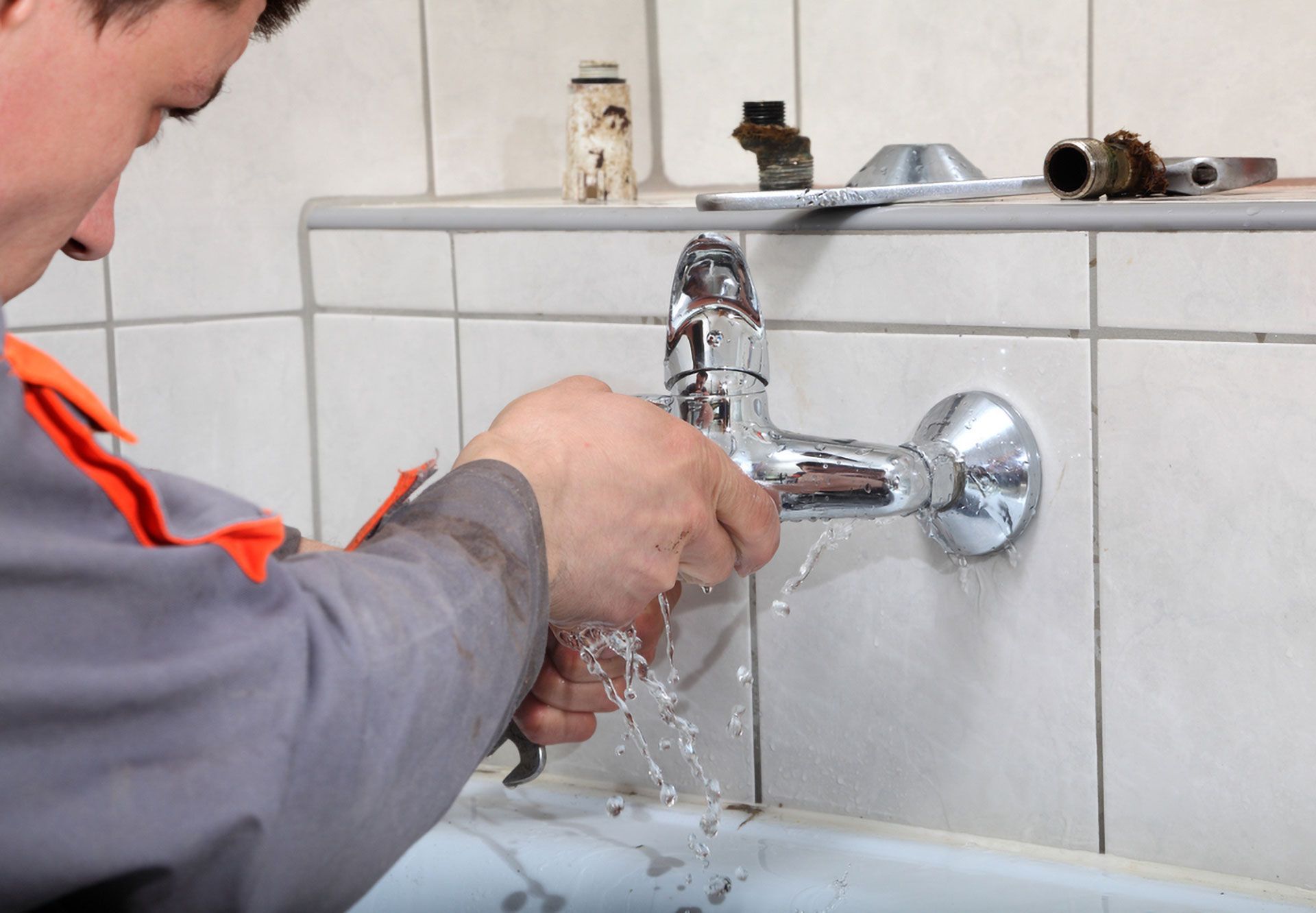 Plumber Fixing a Leaky Faucet in a Bathroom, Water Spraying — Full On Plumbing & Gas in Winnellie, NT