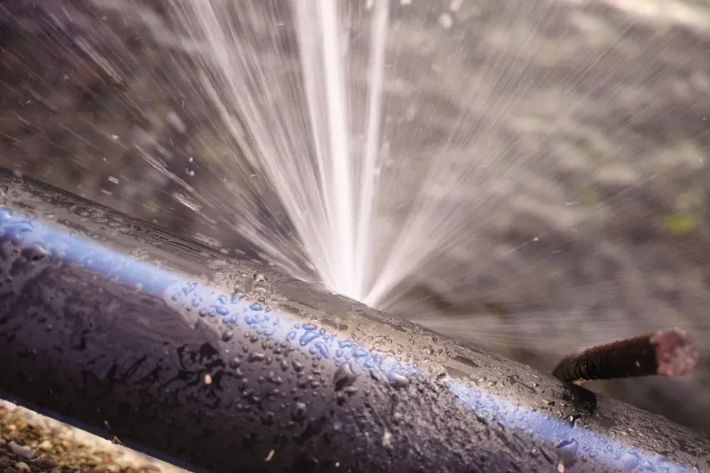 Black Pipe With a Hole Spurting Water — Full On Plumbing & Gas in Winnellie, NT