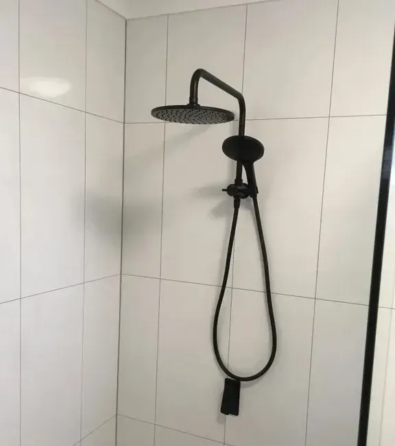 Black Showerhead and Hand Shower on White Tiled Wall — Full On Plumbing & Gas in Winnellie, NT
