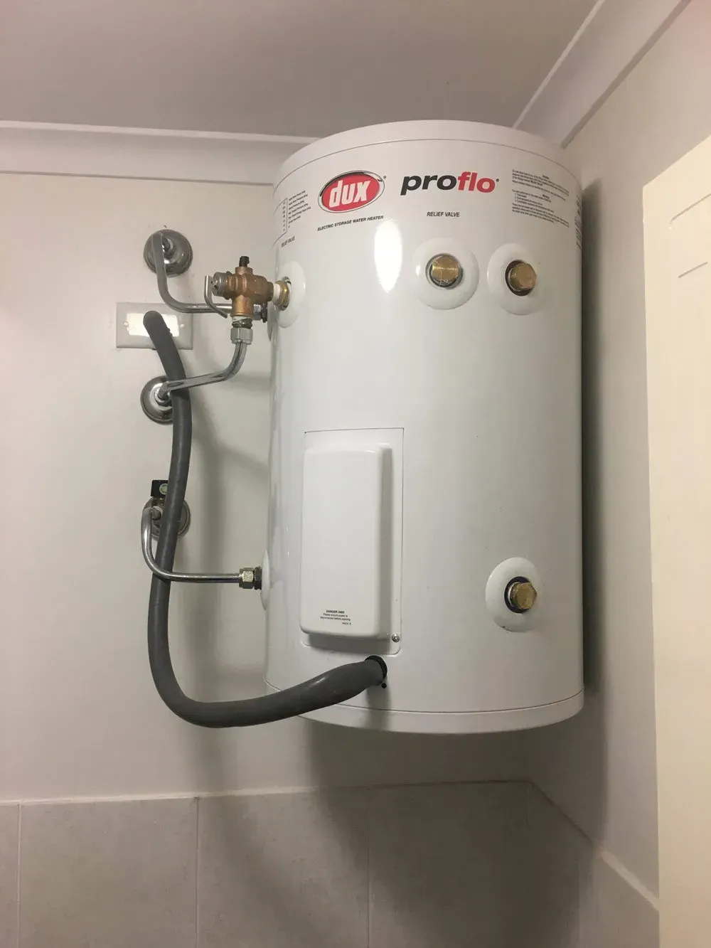 White Water Heater Tank Mounted on a White Wall, With Piping and Controls Visible — Full On Plumbing & Gas in Winnellie, NT
