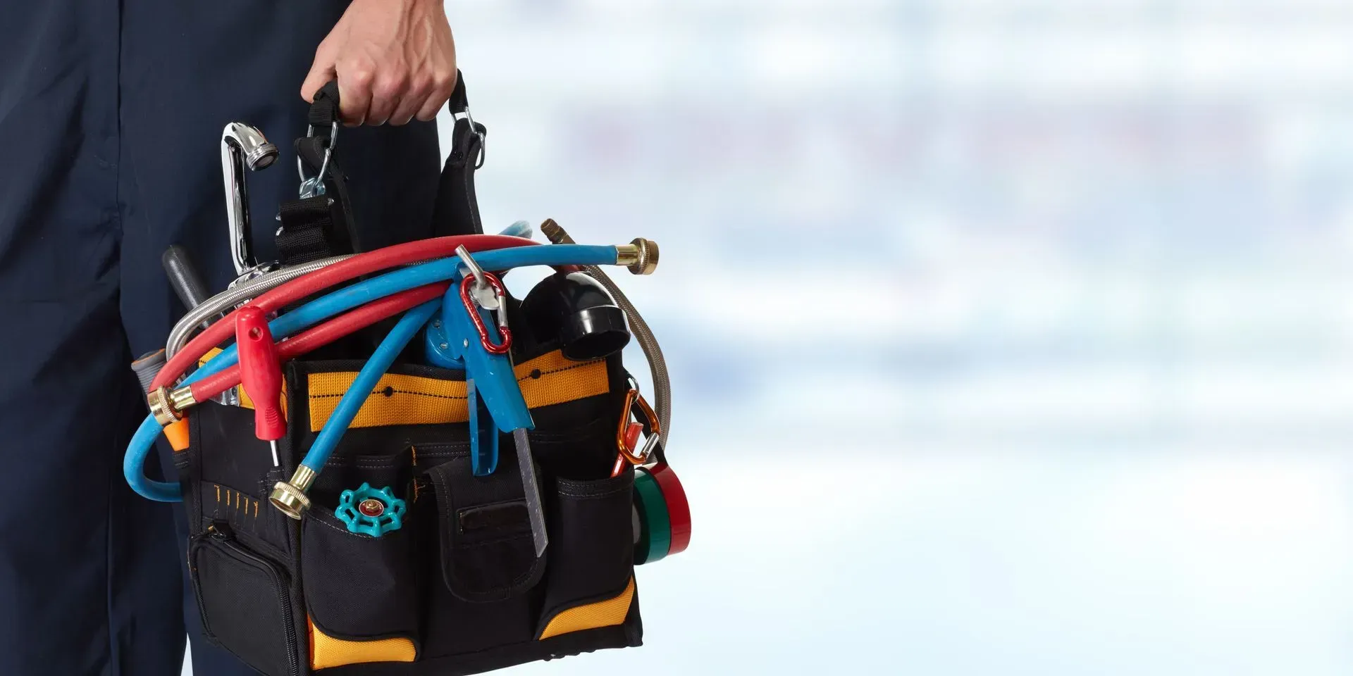 Person Carrying a Black Tool Bag With Hoses and Tools, on a Blue-white Background — Full On Plumbing & Gas in Casuarina, NT