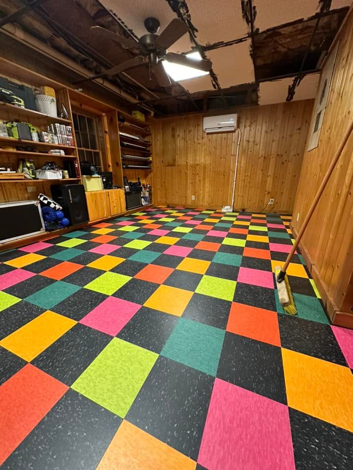 Room with checkered multi-colored floor, wooden walls, and damaged ceiling.