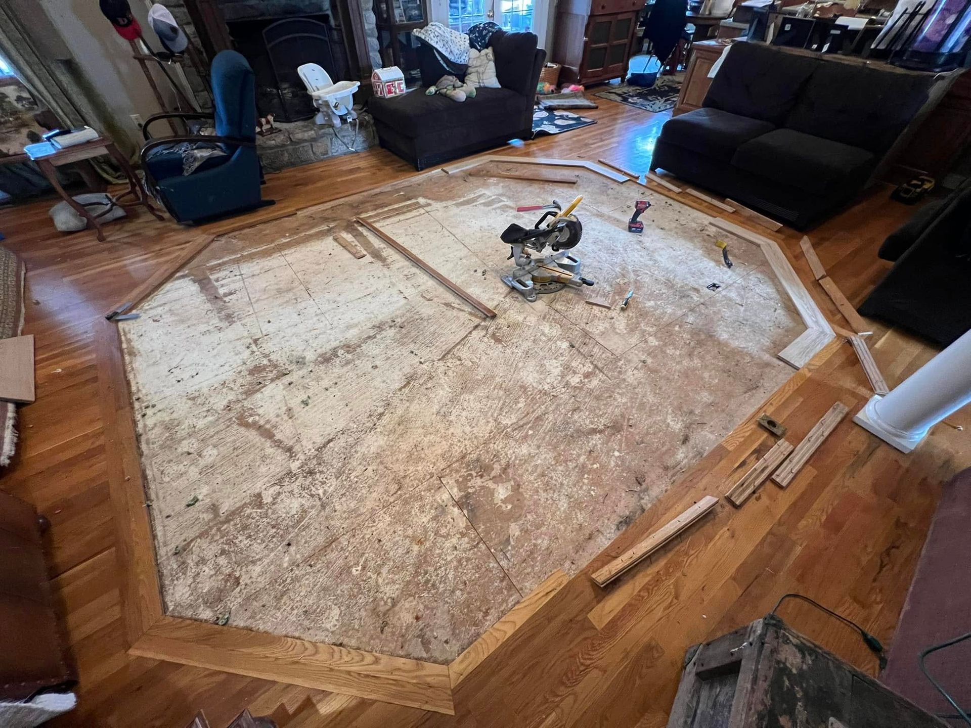 Hardwood floor being renovated, with octagonally shaped section removed. Tools and materials are visible.