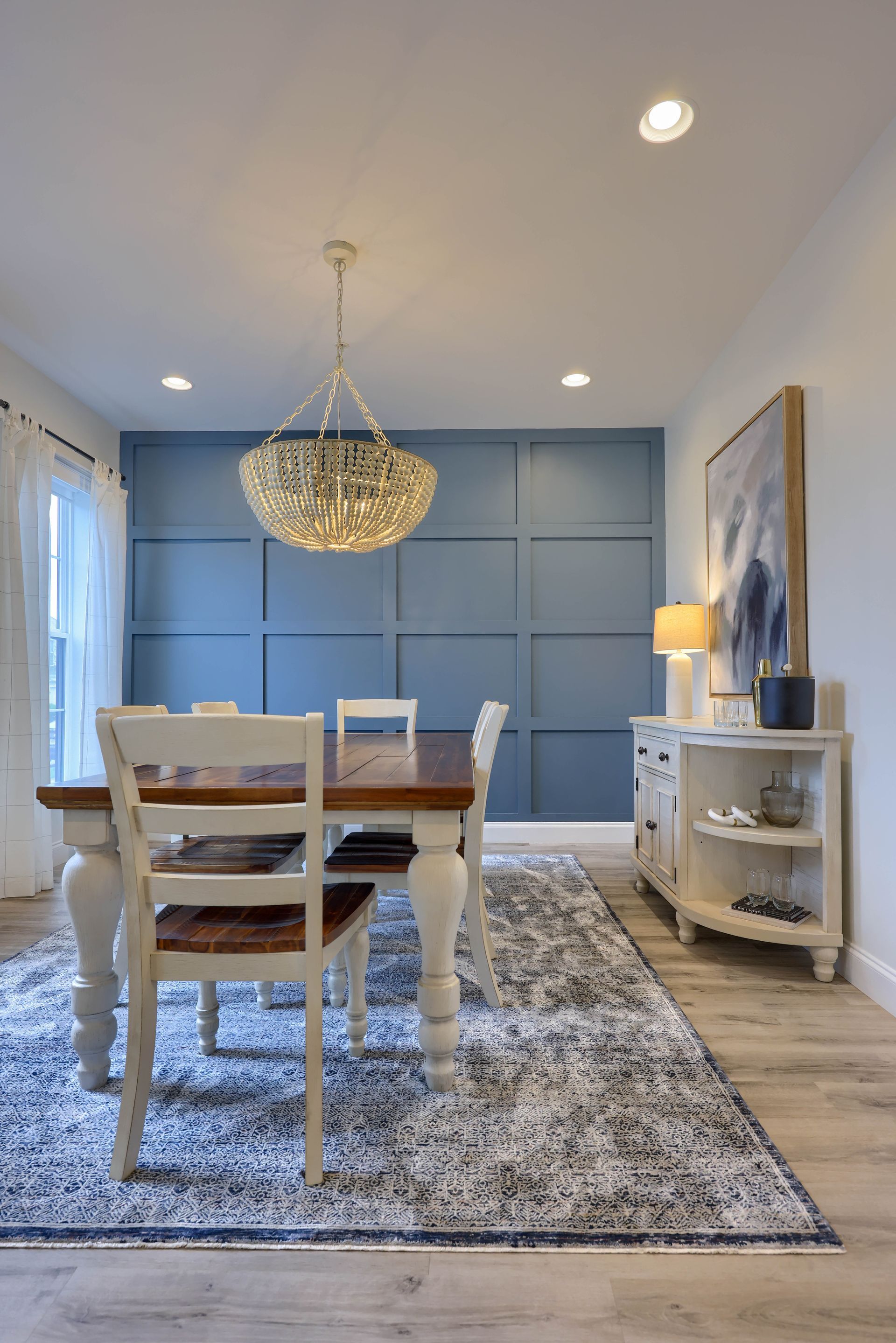 A dining room with a table and chairs and a rug.