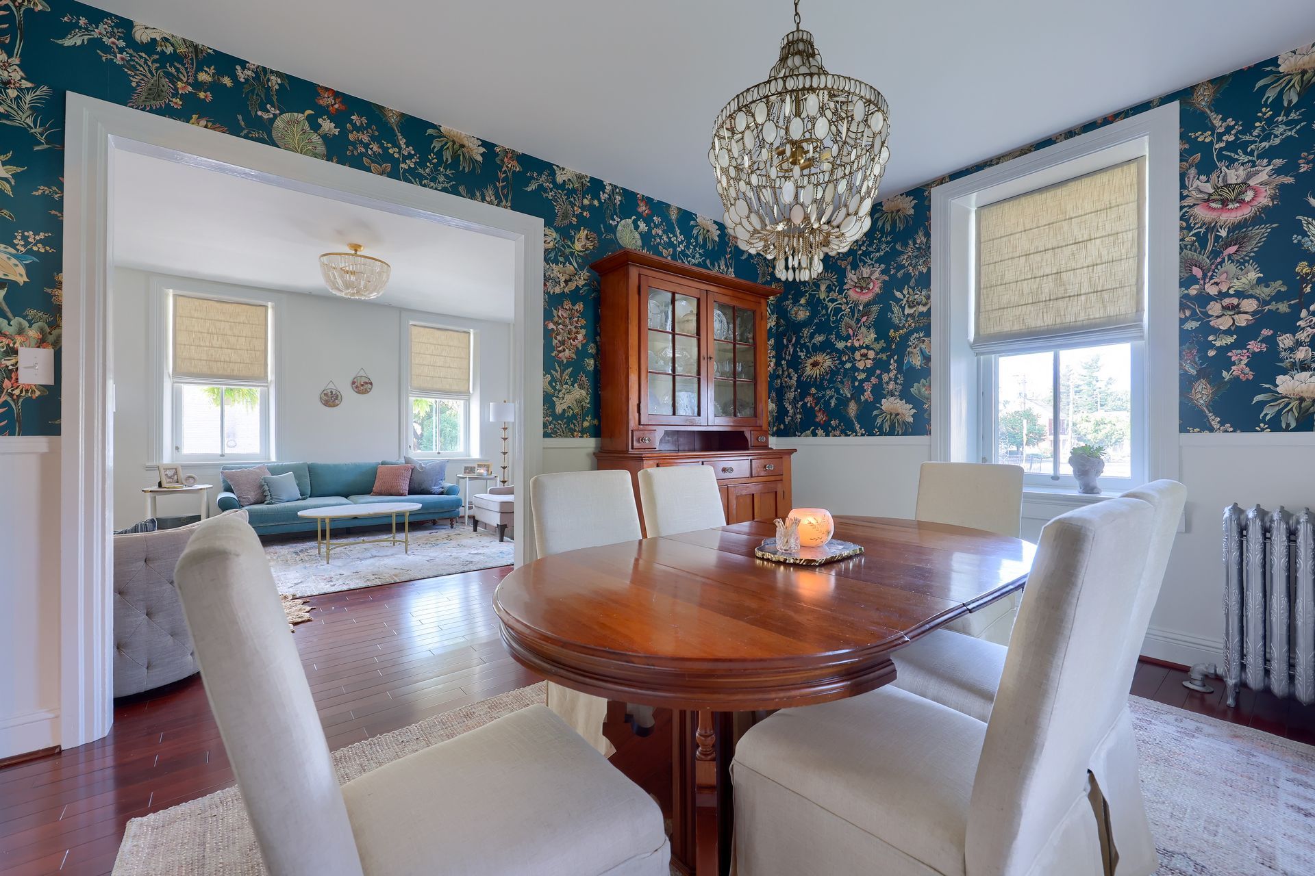 A dining room with a table and chairs and a chandelier.
