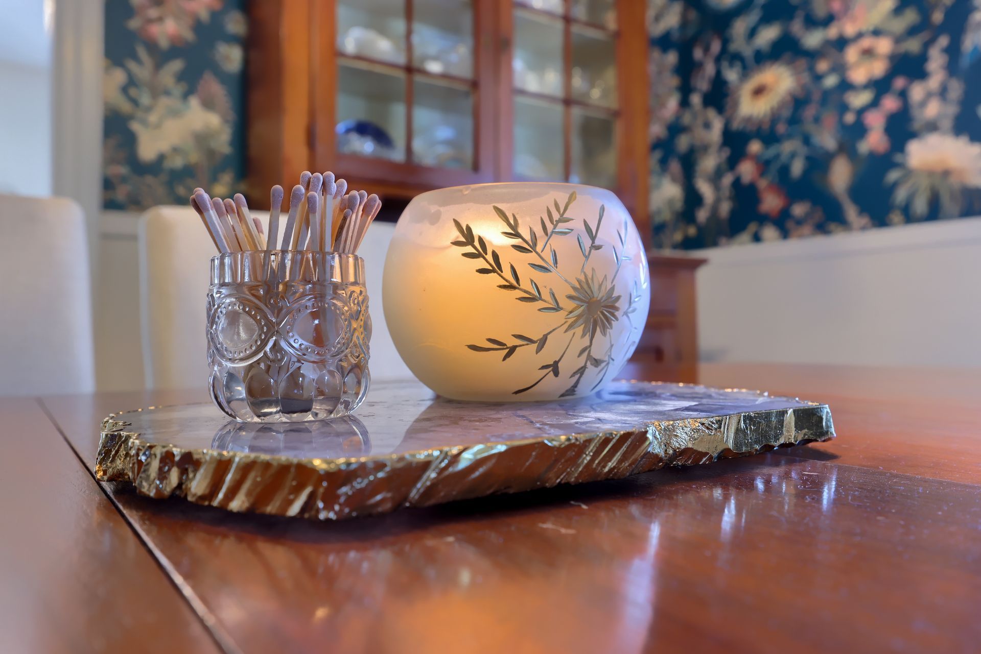 A candle is sitting on a tray on a table.