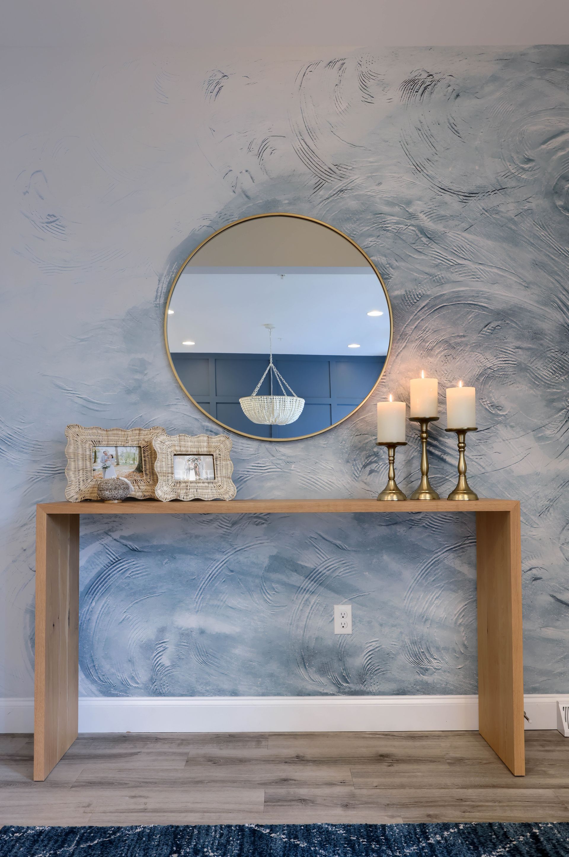 A table with candles and a mirror on it in a living room.