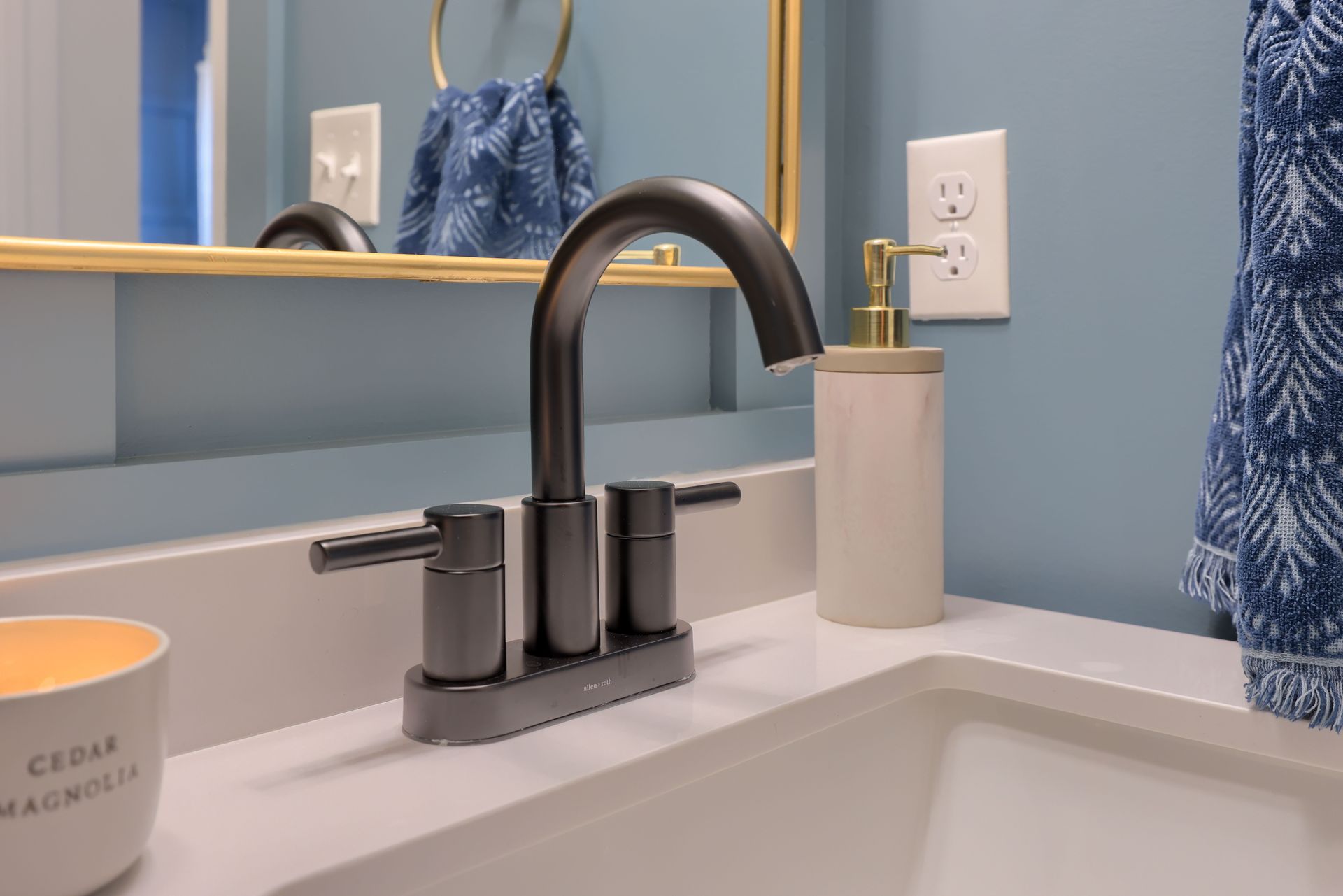 A bathroom sink with a black faucet and a soap dispenser.