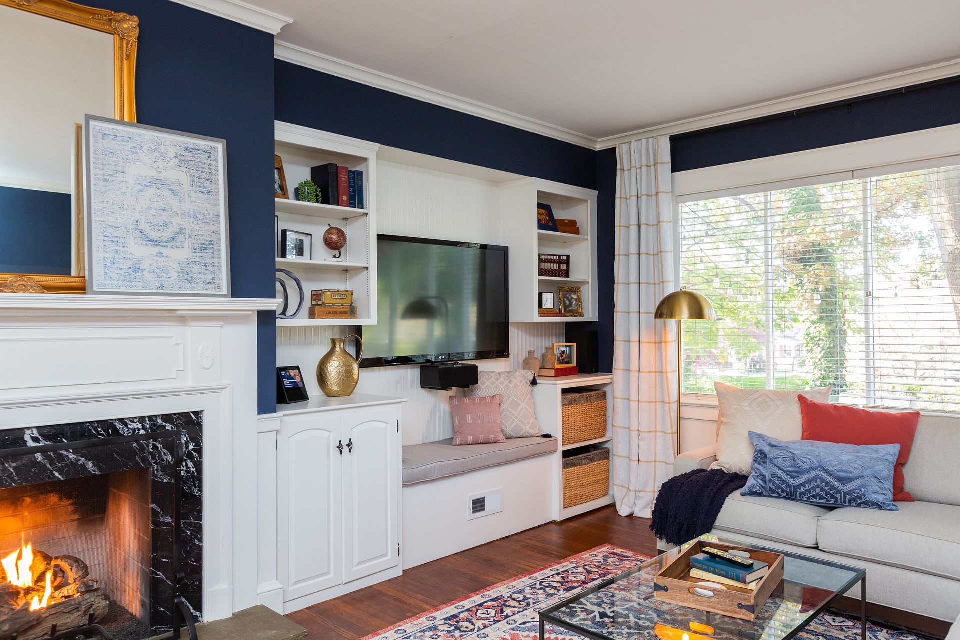 A living room with a fireplace , couch , and television.