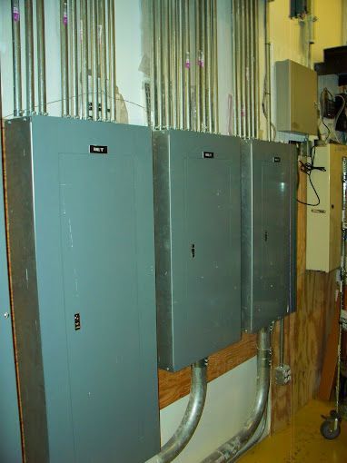 A bunch of electrical boxes are hanging on a wall.