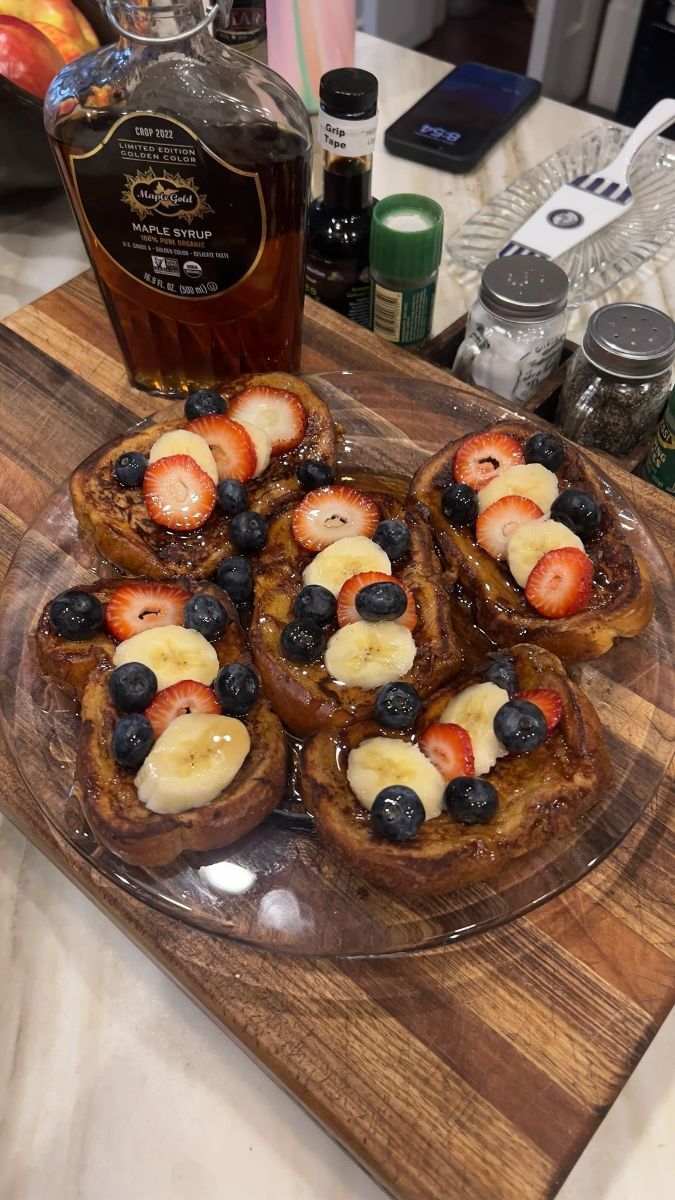 A glass dome filled with brownies is on a wooden table.