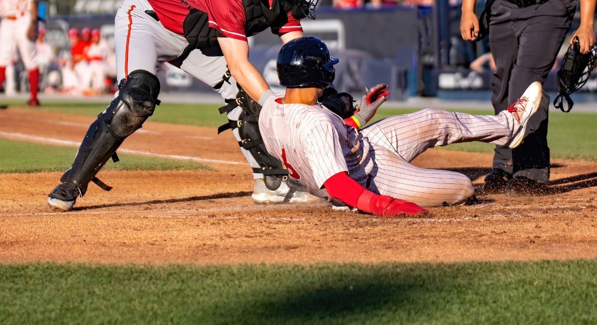A baseball player is sliding into home plate during a game.