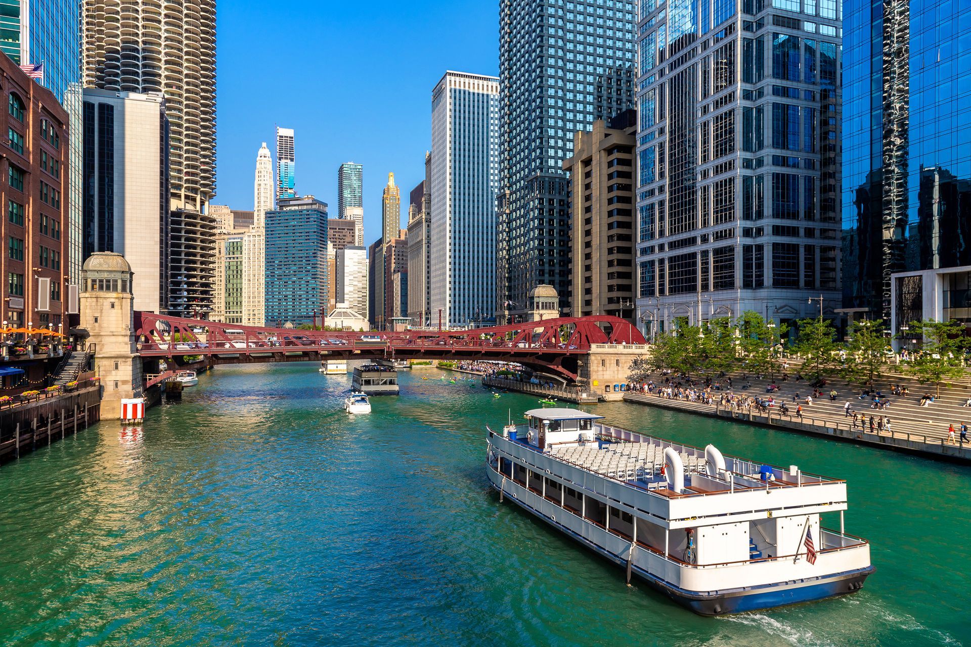 A boat is floating down a river in a city.