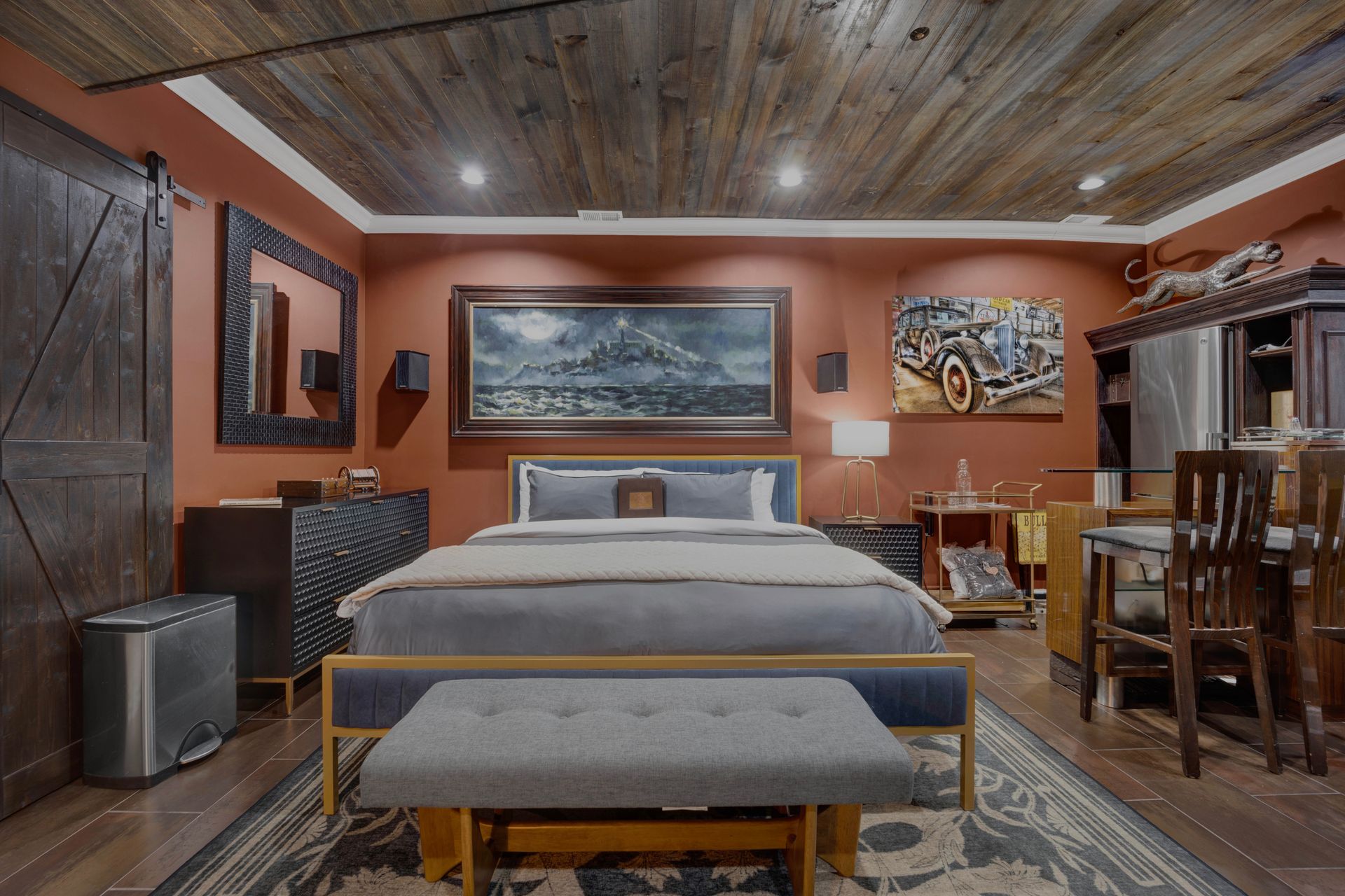 A bedroom with a large bed and a painting on the wall.