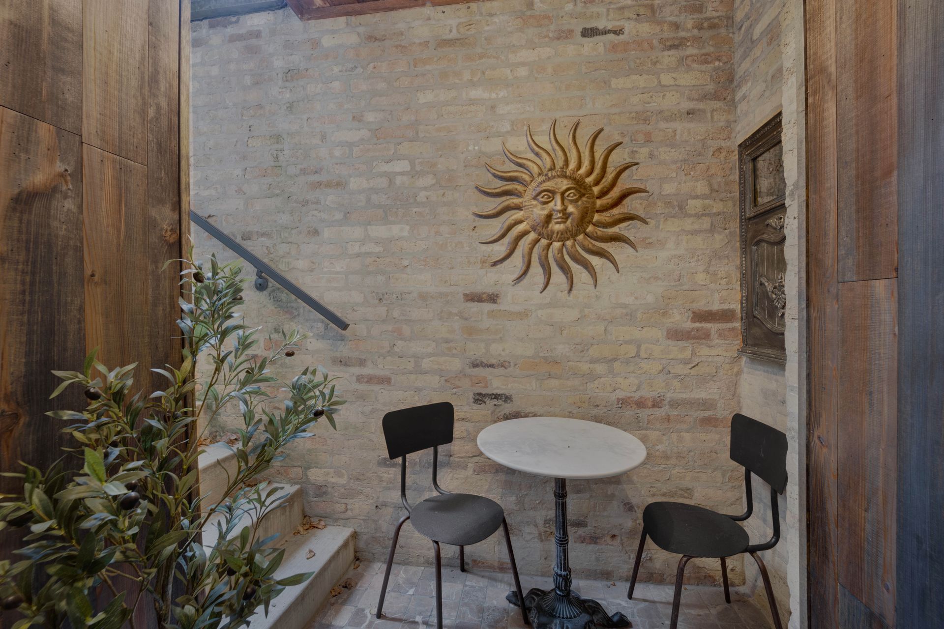 A small room with a table and chairs and a sun on the wall.