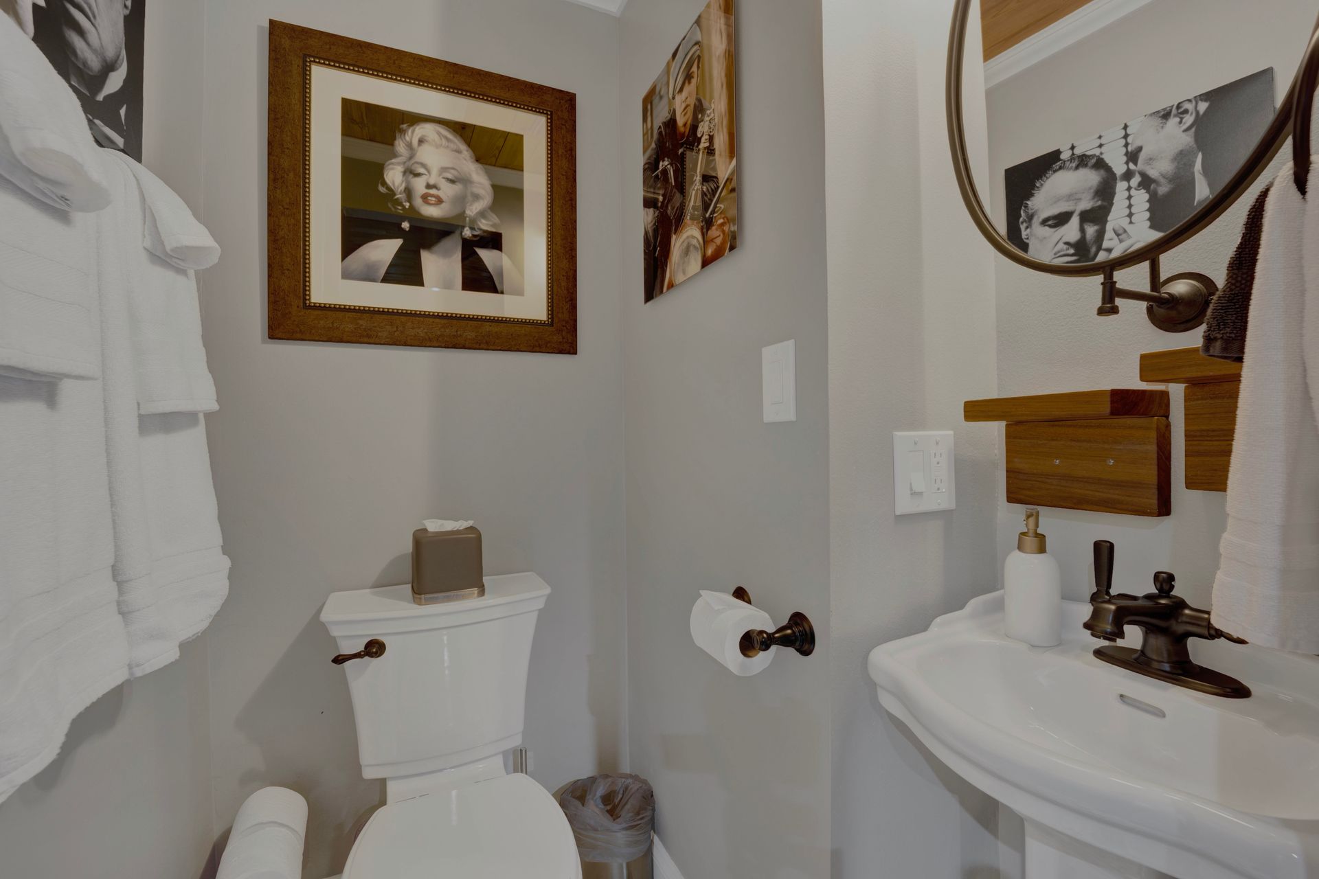 A bathroom with a toilet , sink and mirror.