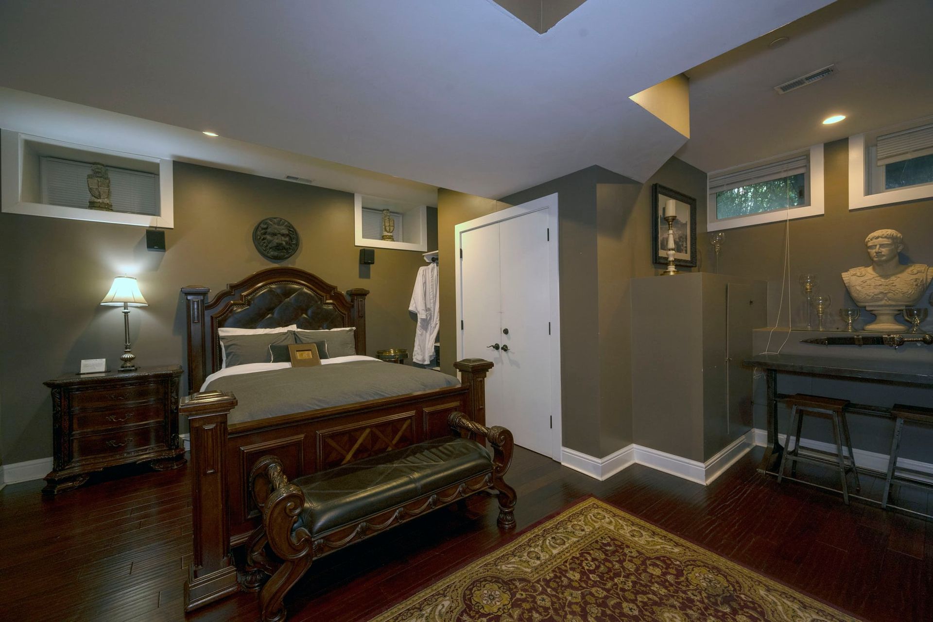 A bedroom with a large bed and a bench