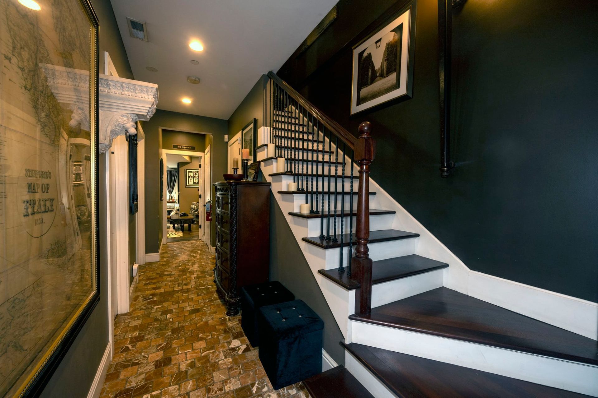 A hallway with stairs and a map on the wall