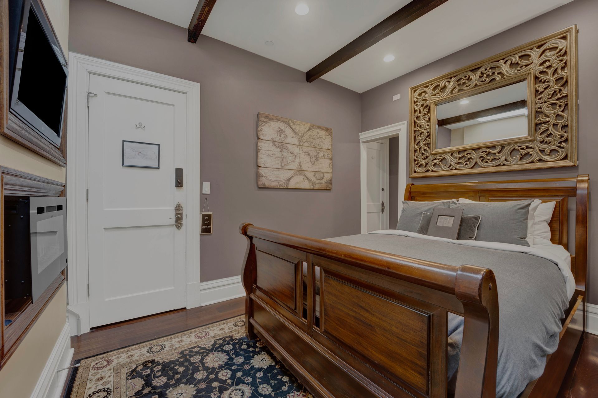 A bedroom with a king size bed and a large mirror.