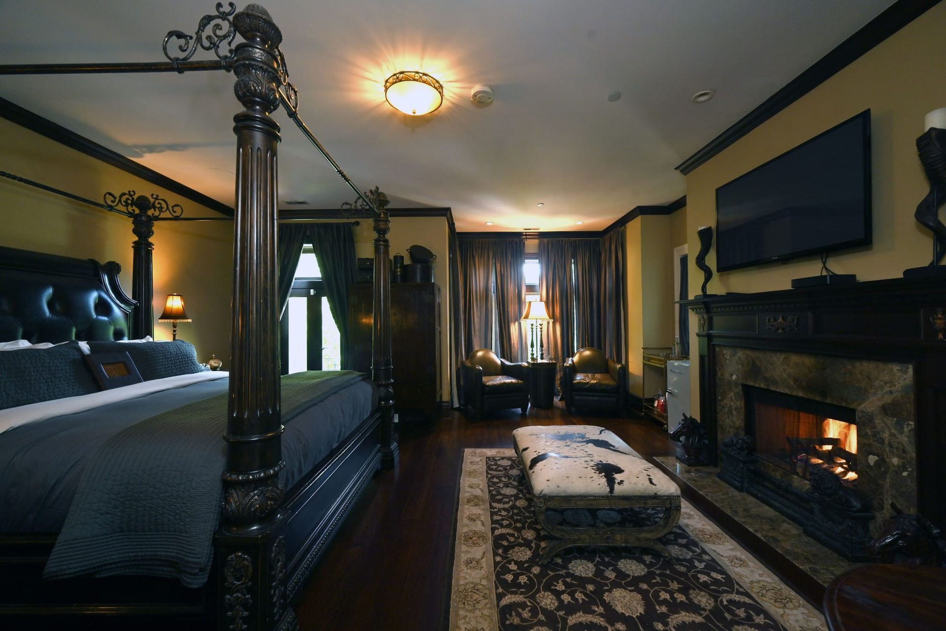 A bedroom with a four poster bed and a fireplace