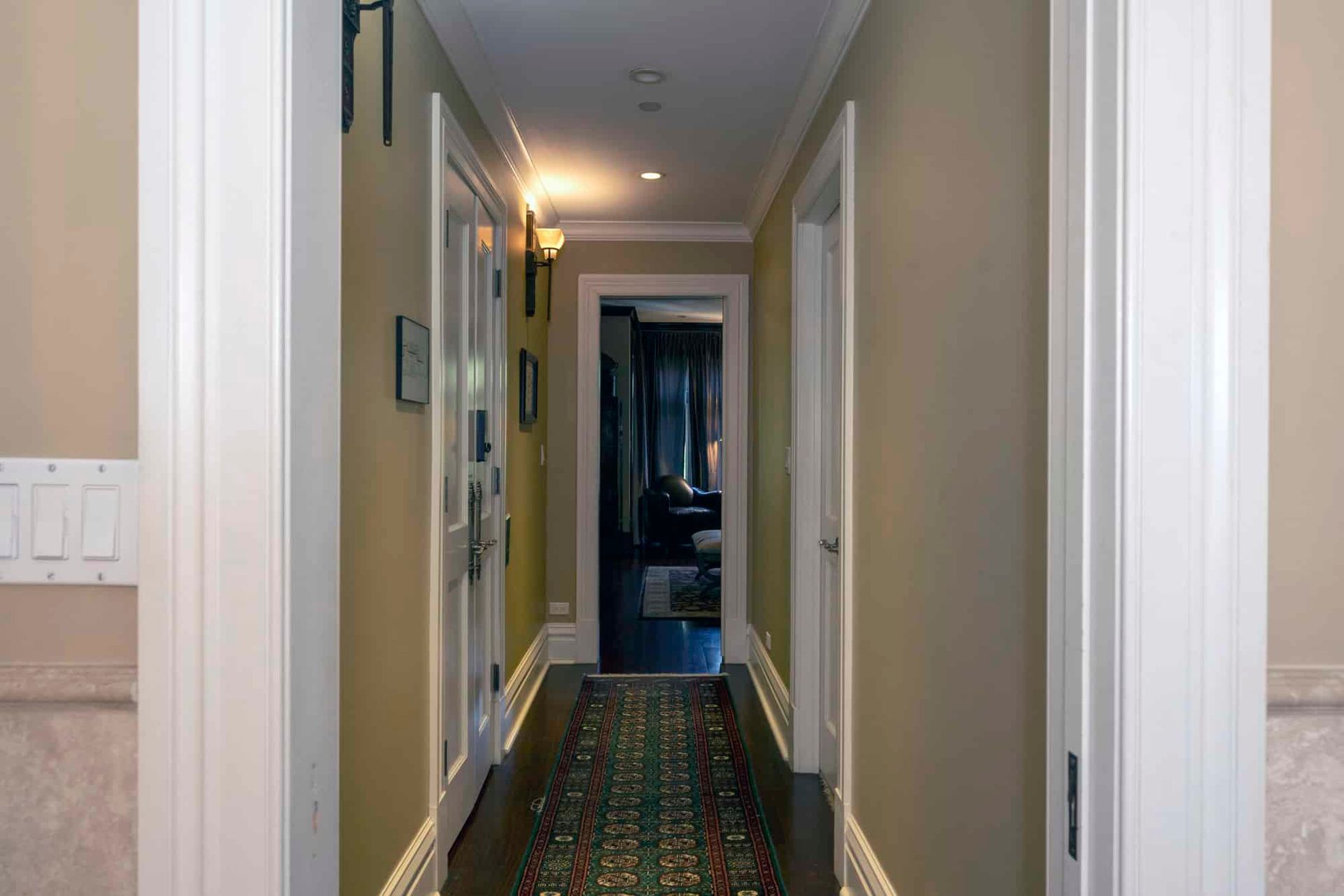 A long hallway in a house with a rug on the floor.