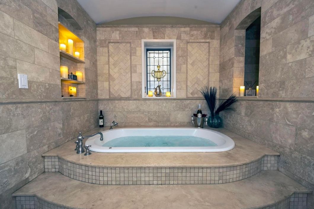 A bathroom with a jacuzzi tub and a window.