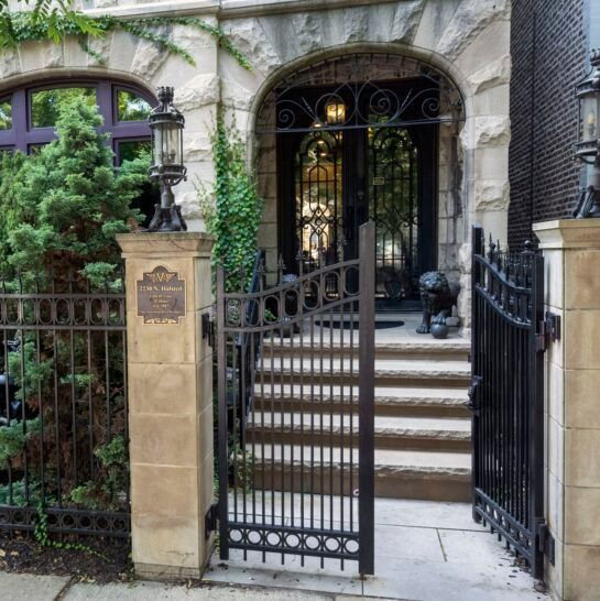 A wrought iron gate leading to a house with stairs