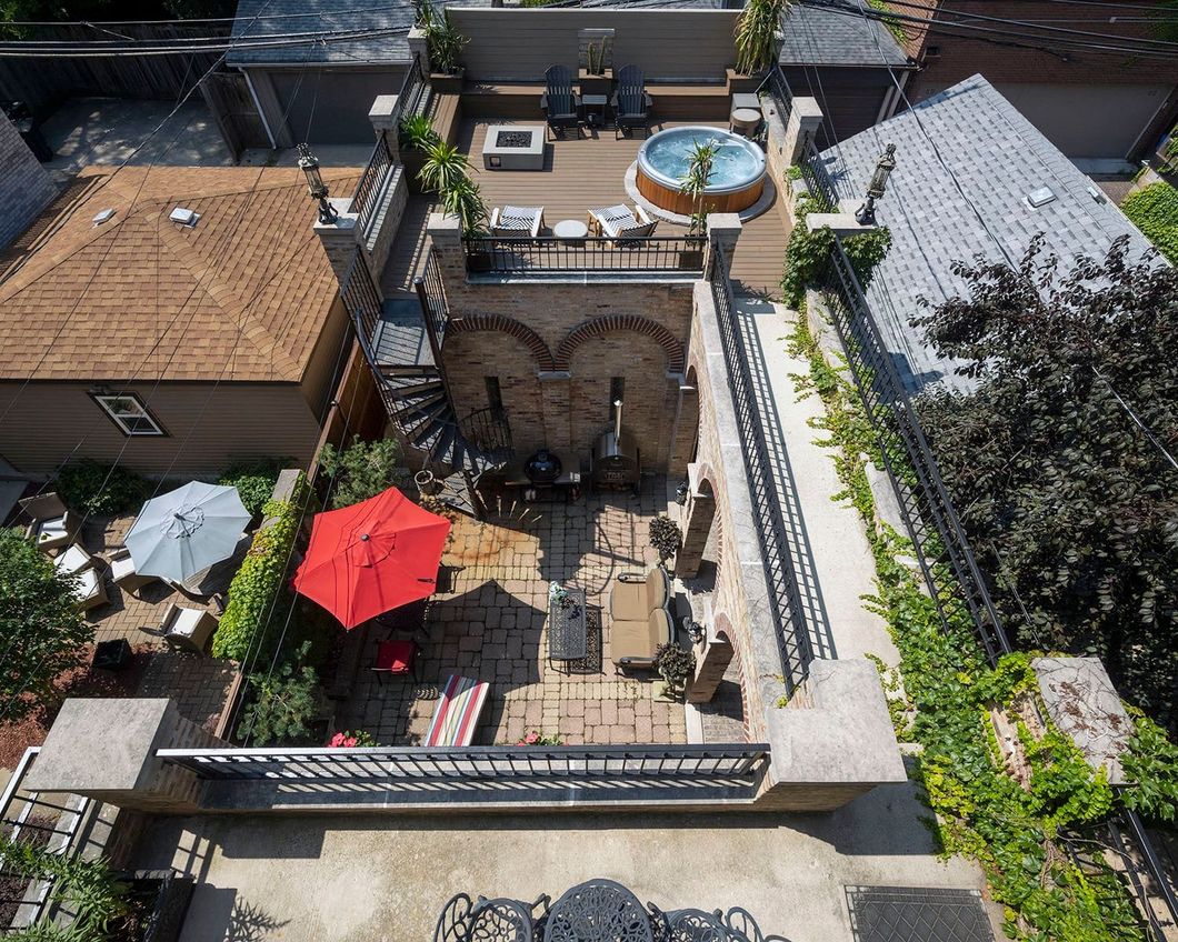 An aerial view of a backyard with a hot tub and umbrellas