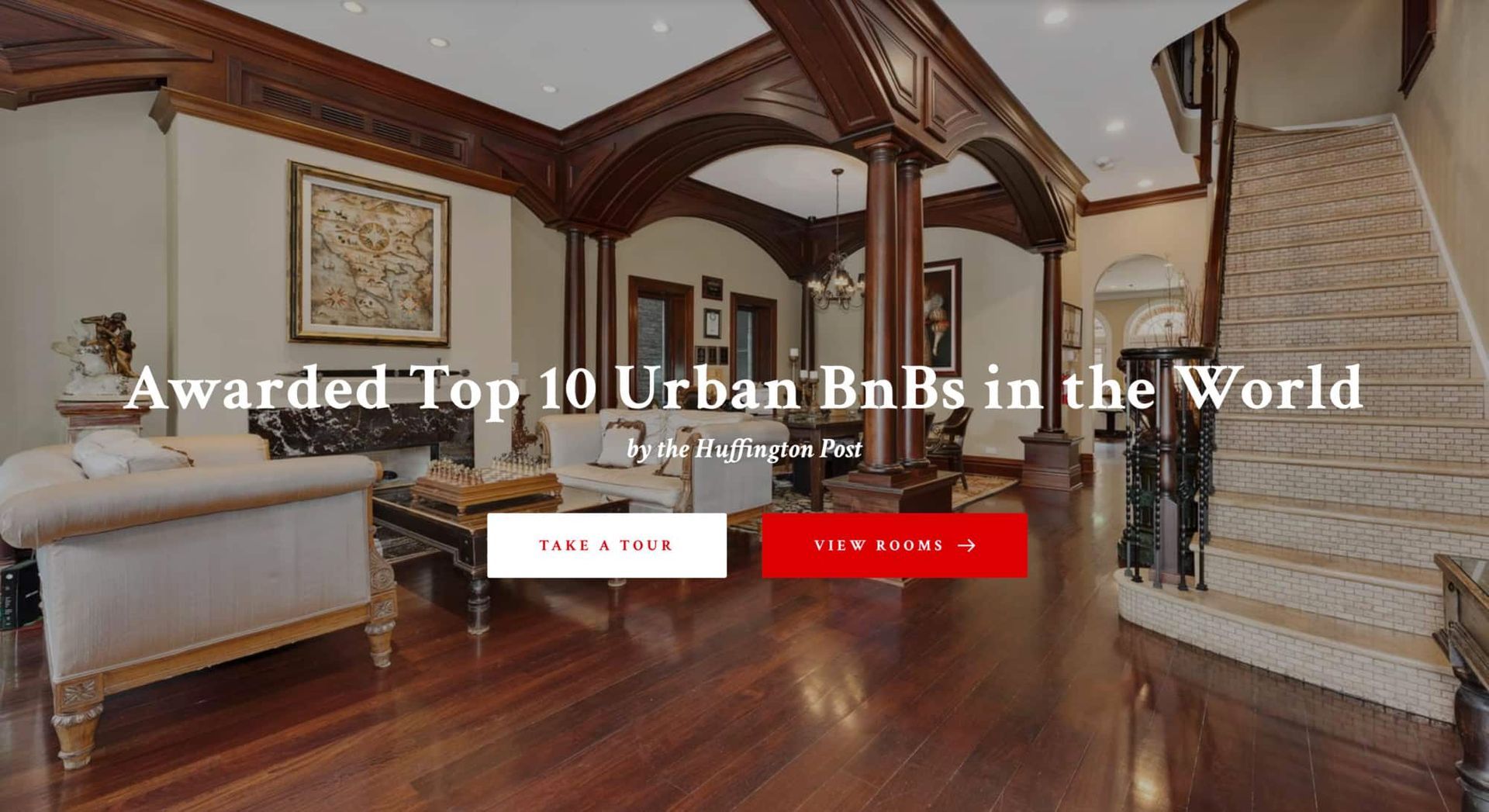 A living room with wooden floors and a staircase.