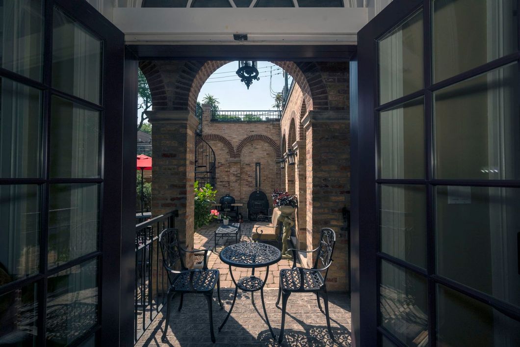 A view of a patio with a table and chairs through a glass door.