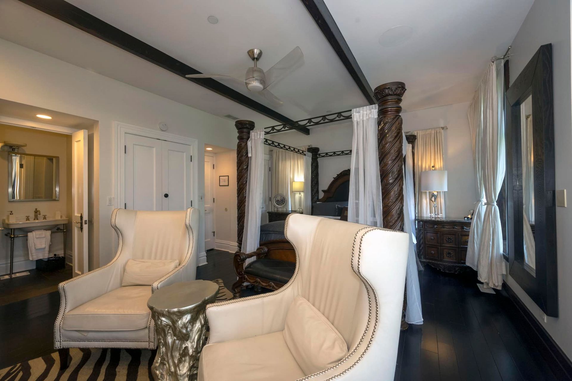 A bedroom with a canopy bed and two chairs