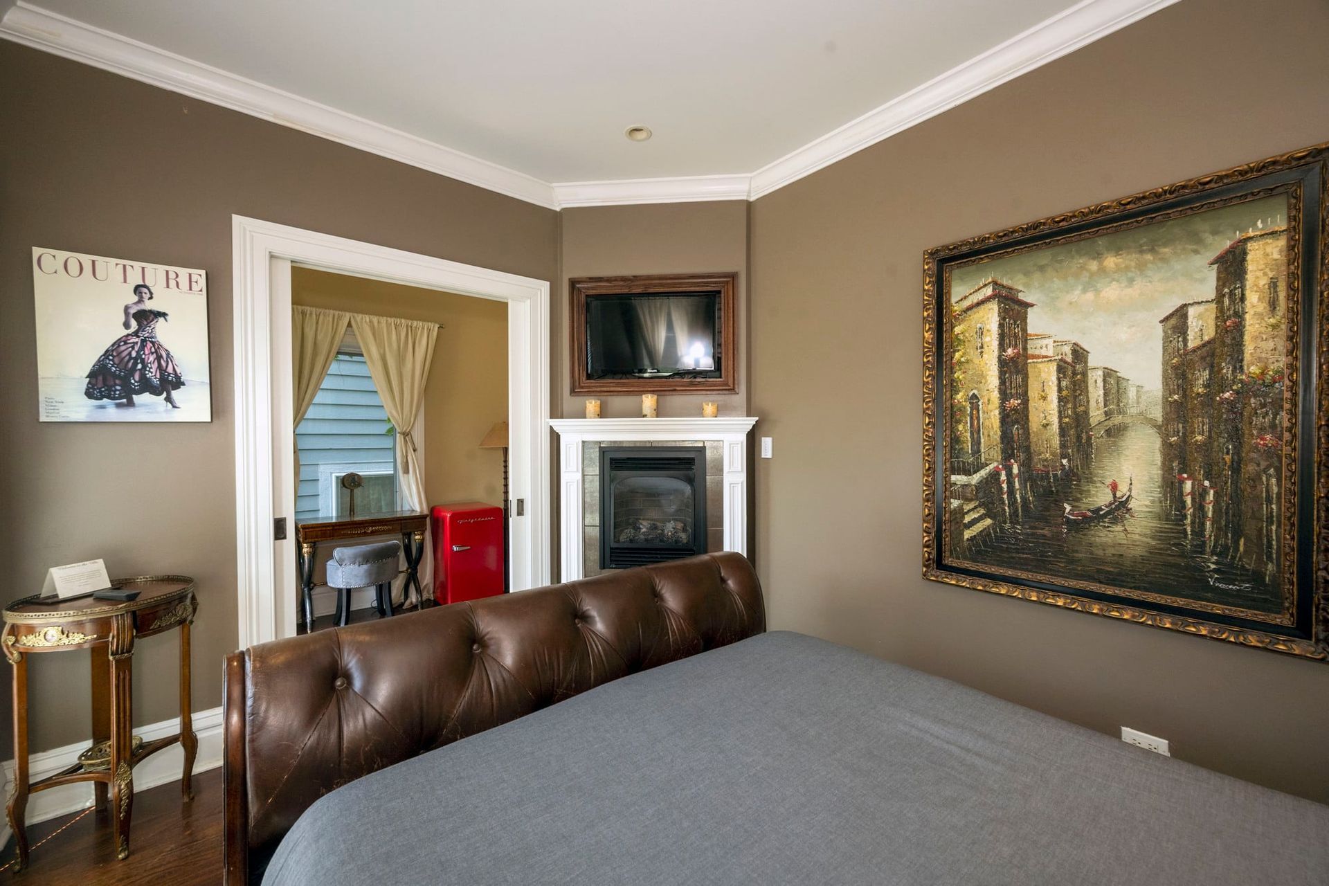 A bedroom with a large bed and a fireplace