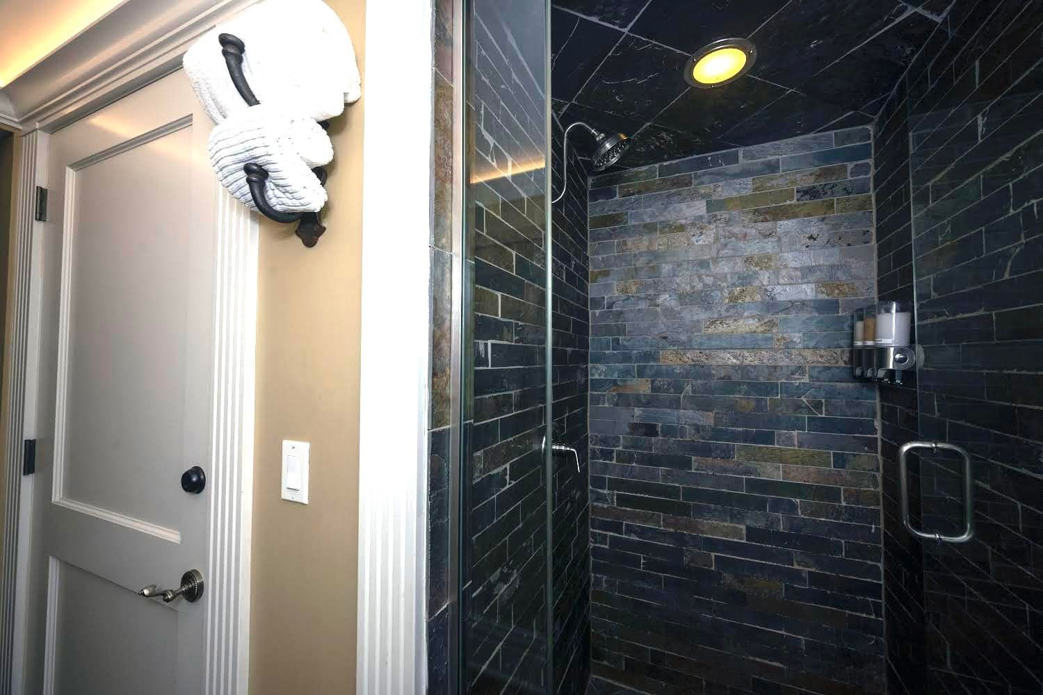 A bathroom with a walk in shower and a door.