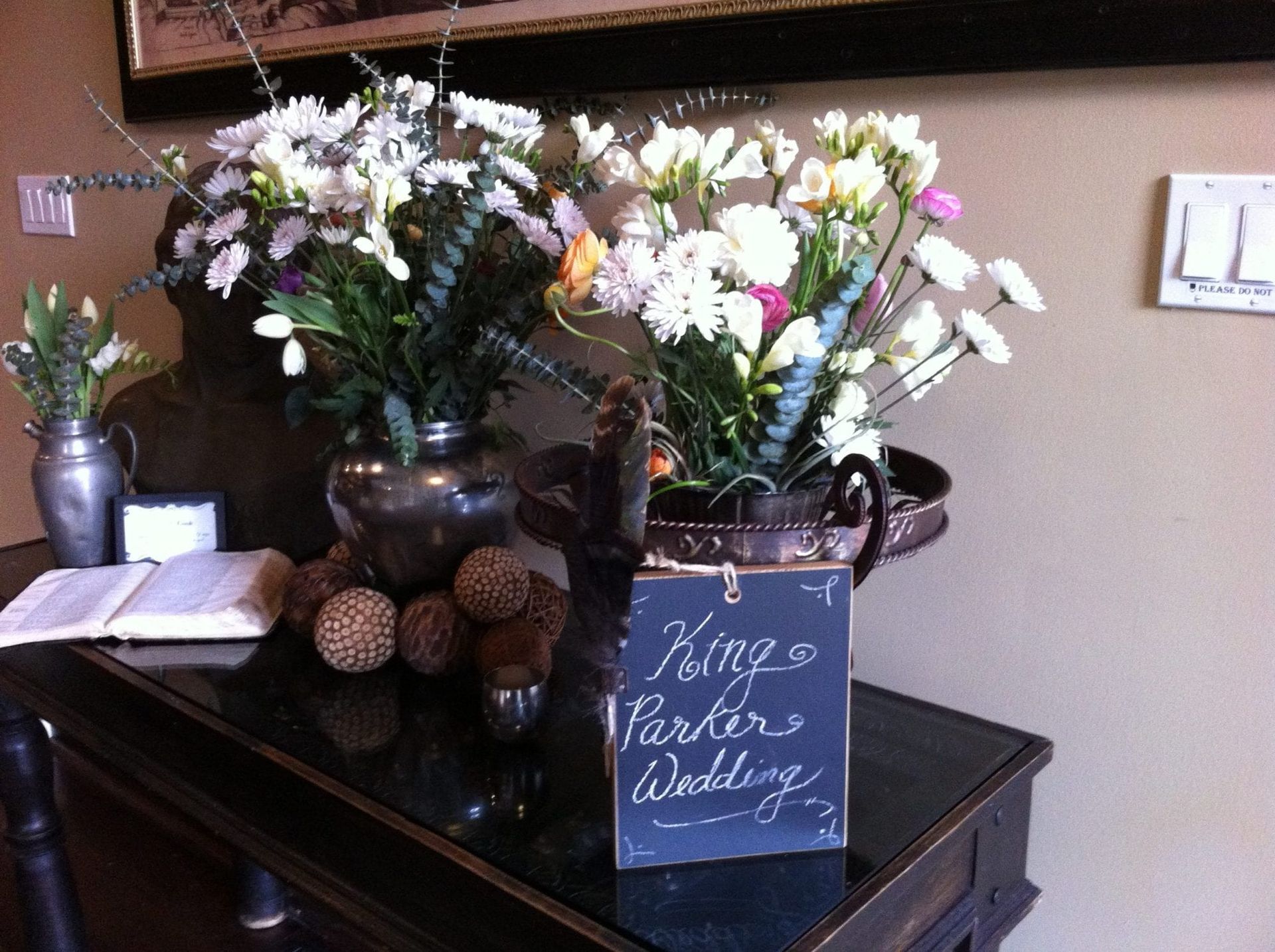 A vase of flowers sits on a table next to a sign that says king parker wedding
