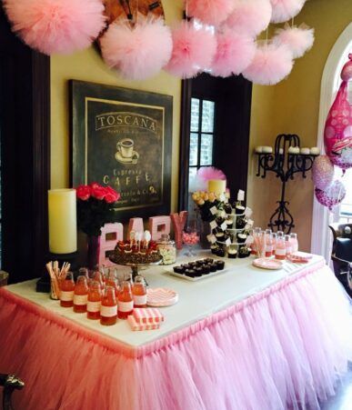 A table with a pink tulle skirt and a sign that says toscana