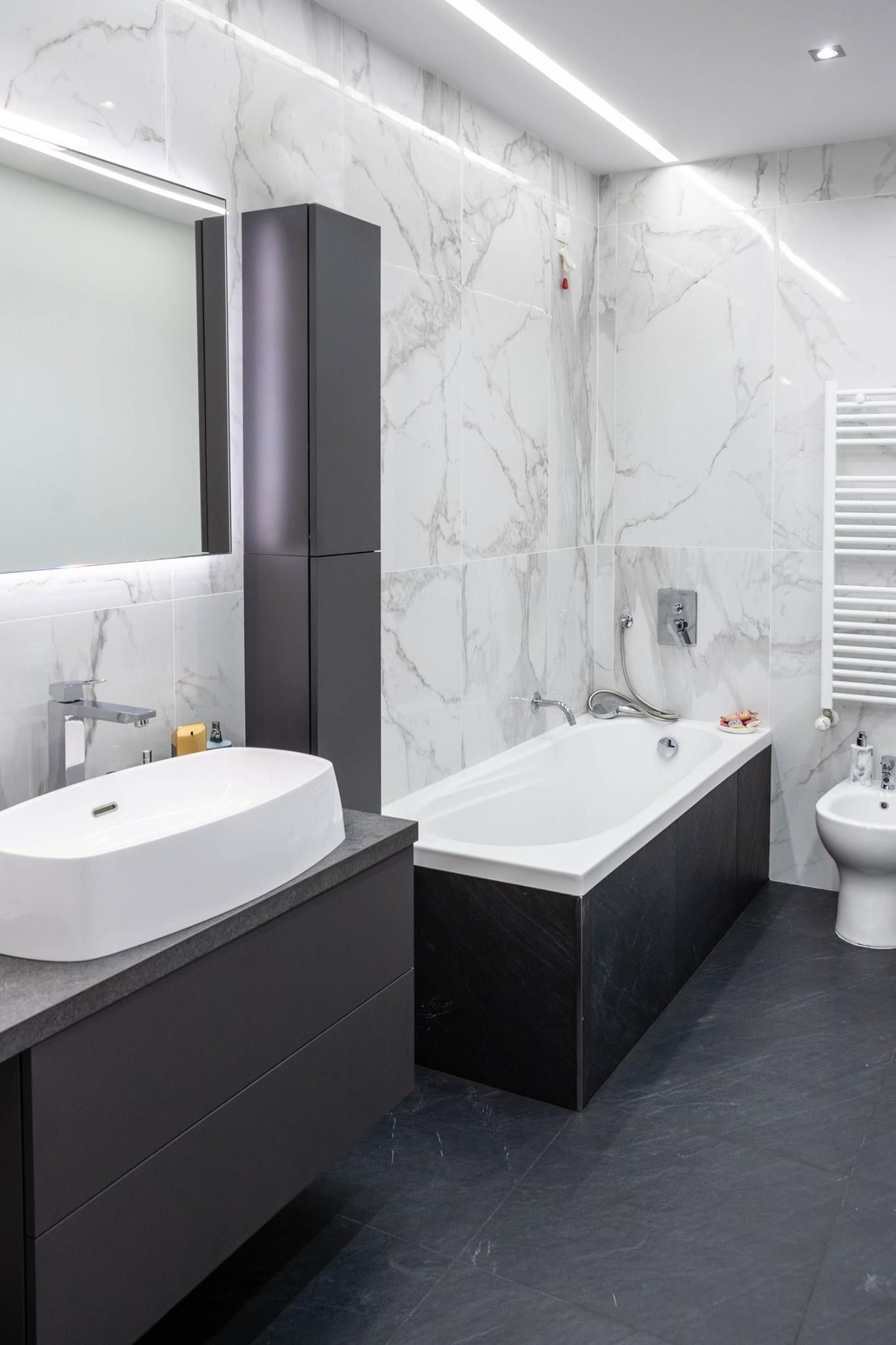 Un bagno ristrutturato con vasca, lavandino, water e specchio.