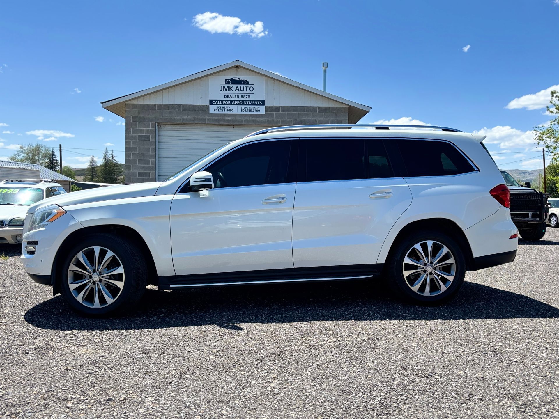 White SUV parked in front of a building under a bright blue sky