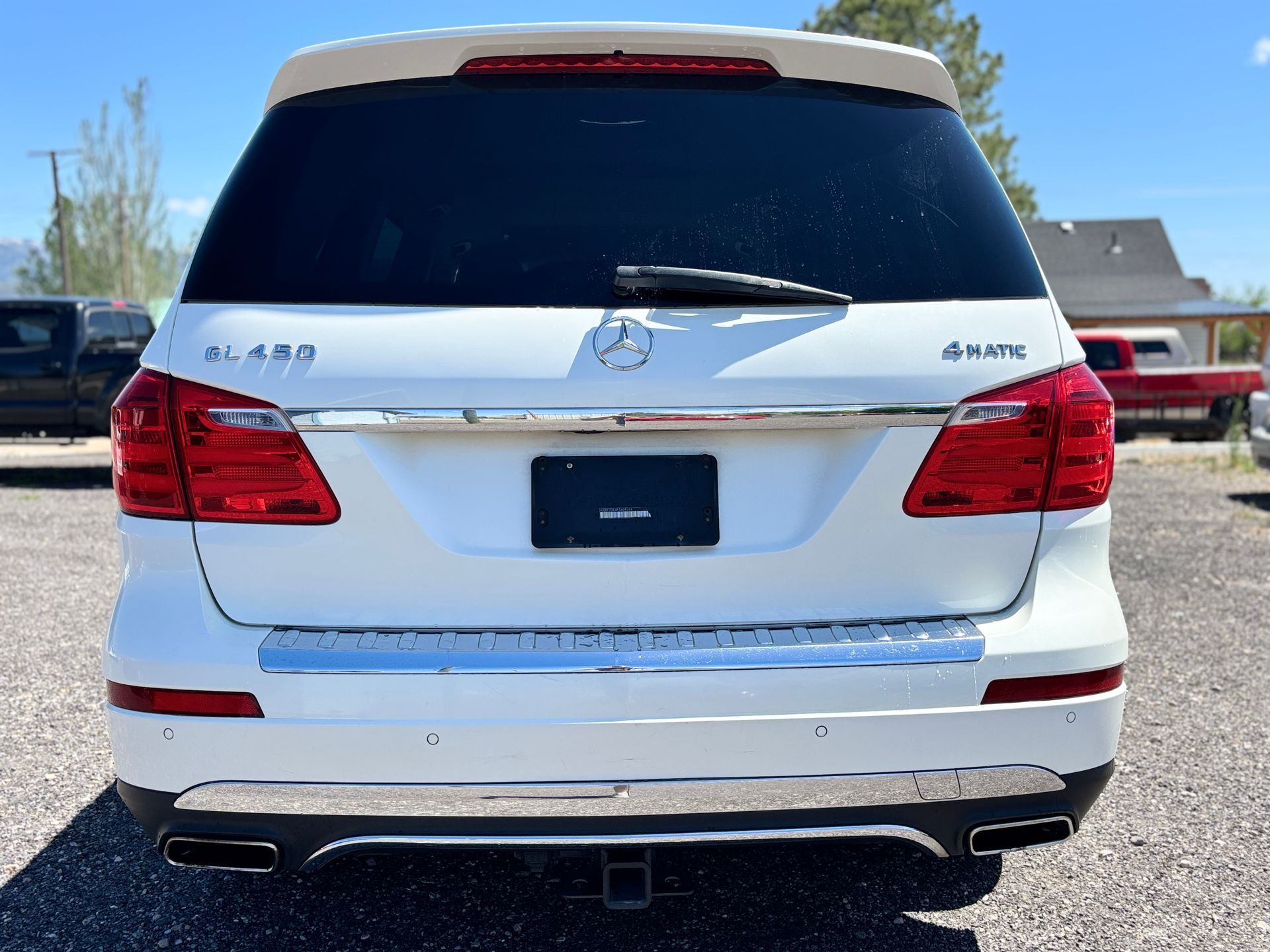 Rear view of a white Hyundai Santa Fe SUV parked outdoors in a lot.