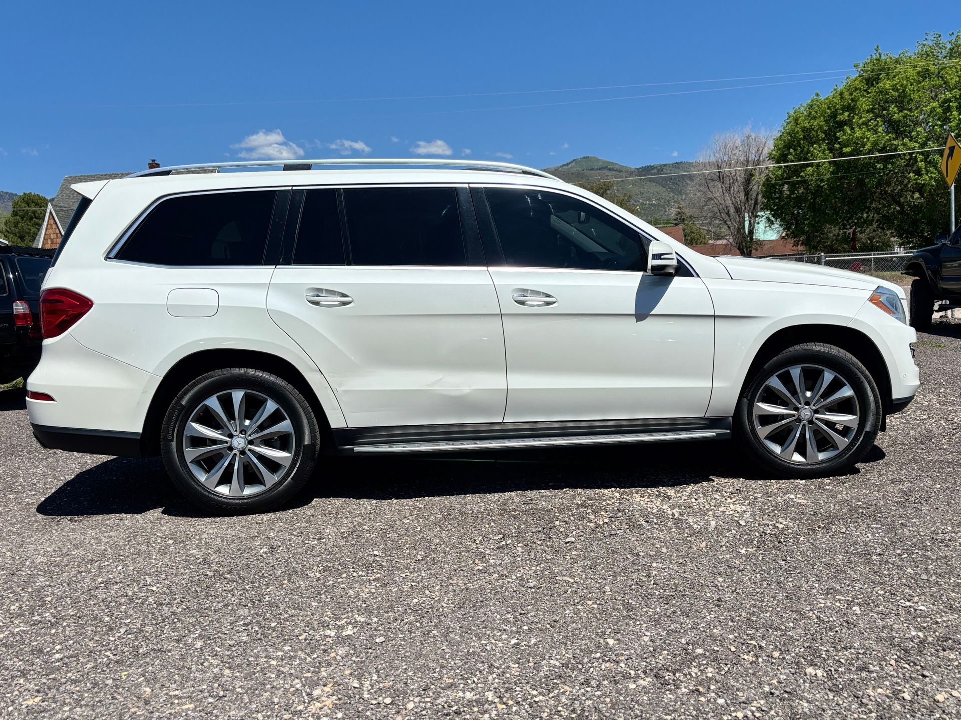 White SUV parked on a gravel lot under a clear blue sky