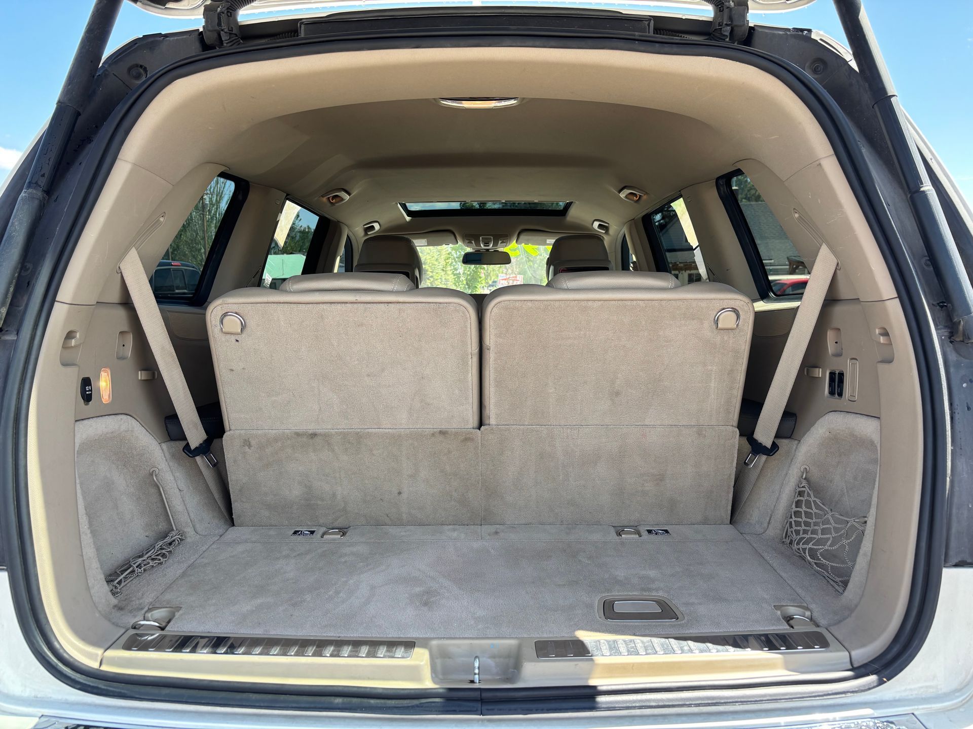 Open SUV cargo area with beige interior and folded rear seats