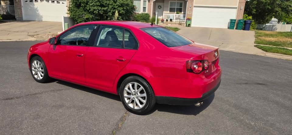 Red sedan parked on a suburban street in daylight