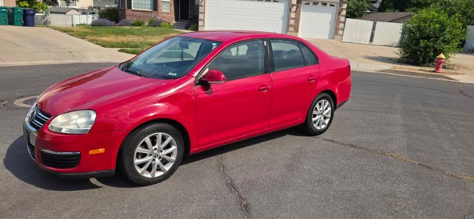 Red sedan parked on a residential street on a sunny day