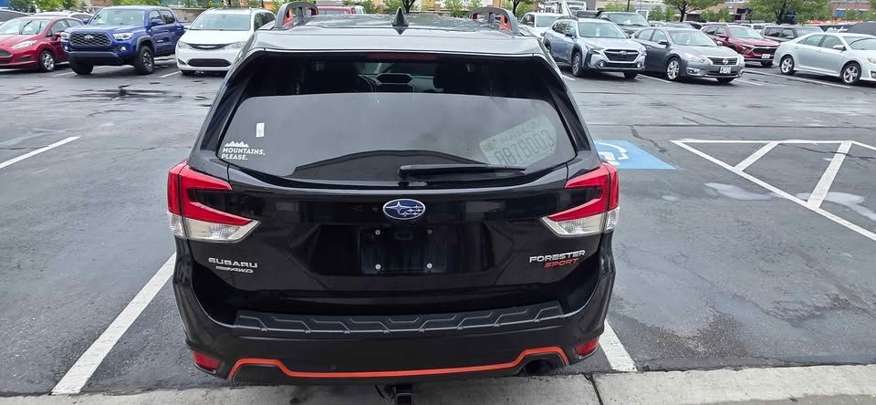 Black Subaru SUV parked in a lot, rear view, with red accents on the bumper.