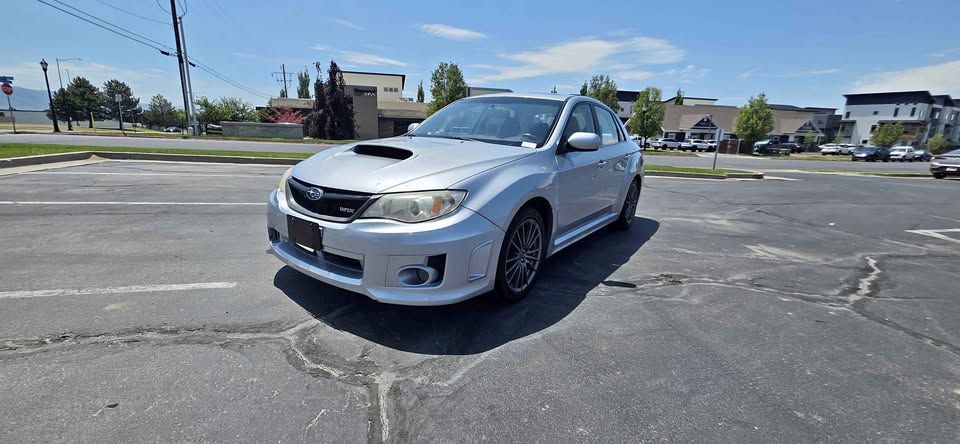 Silver sedan parked in an empty lot under bright sunlight