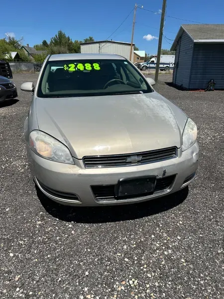 Silver sedan parked outdoors with a neon green price tag on the windshield.