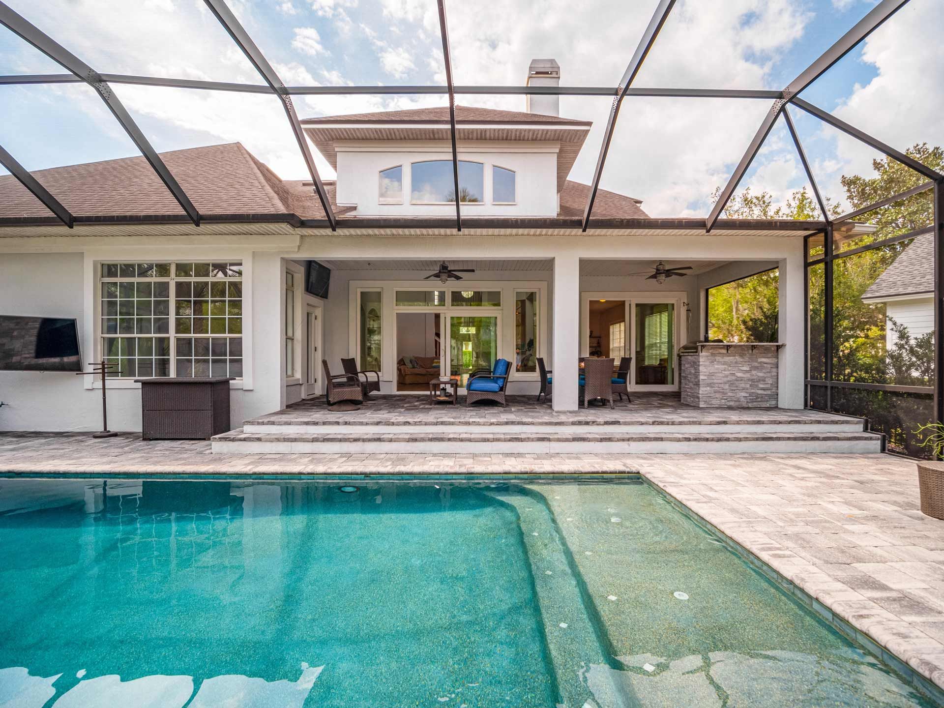 Backyard with a pool and screened-in patio.