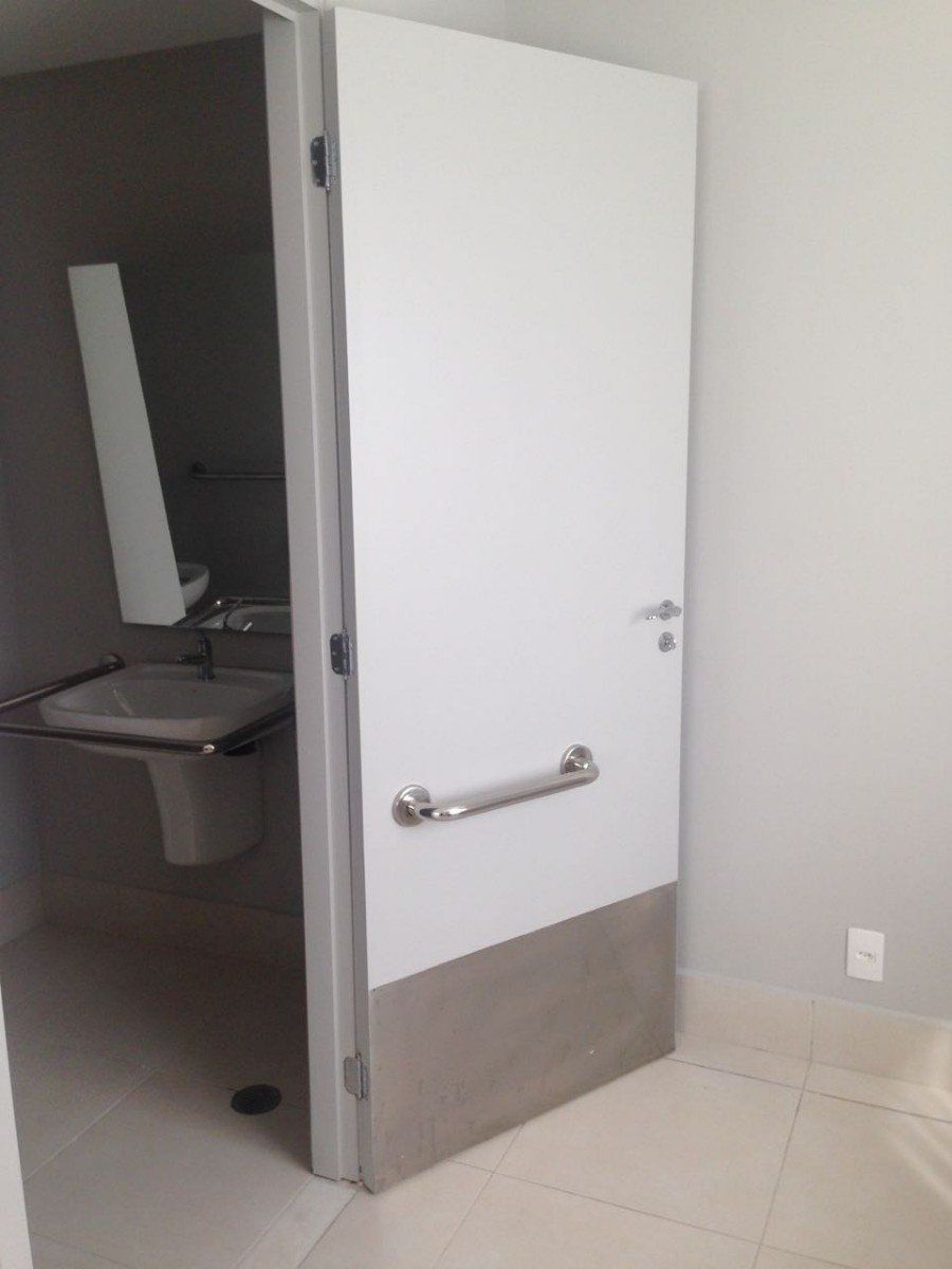 Um banheiro com uma porta branca e uma pia.