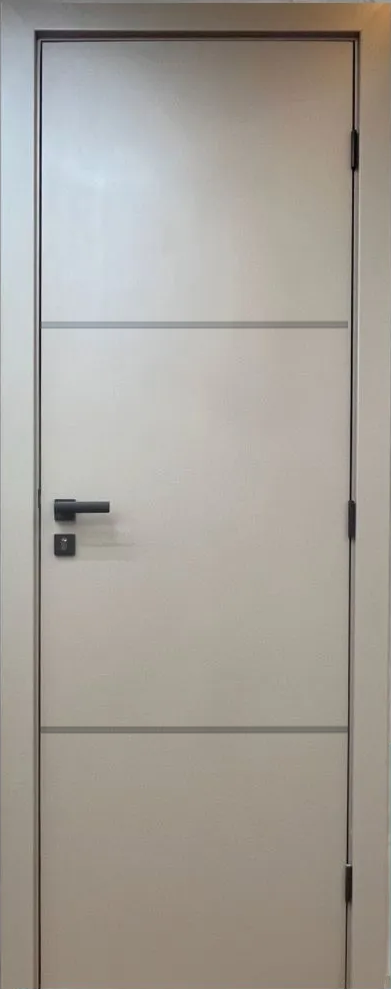 Uma porta branca com uma maçaneta preta está apoiada em uma parede branca.