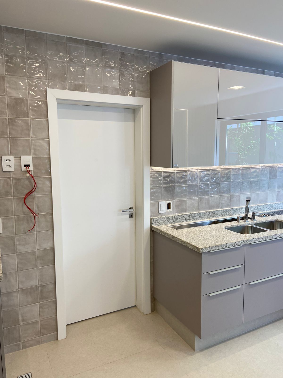 Uma cozinha com uma porta branca e uma pia